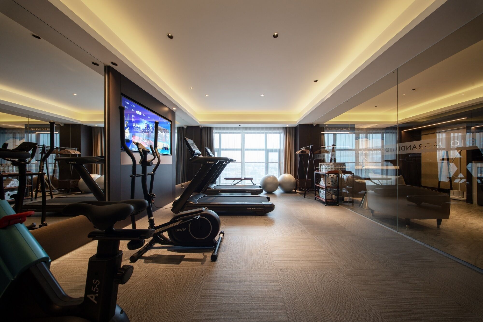 A modern gym with treadmills, stationary bikes, and exercise balls.