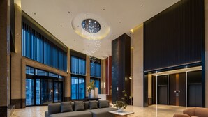A spacious lobby with a sectional sofa, a coffee table, and a chandelier. - Giorgio Morandi Hotel - Bazhou (Langfang)
