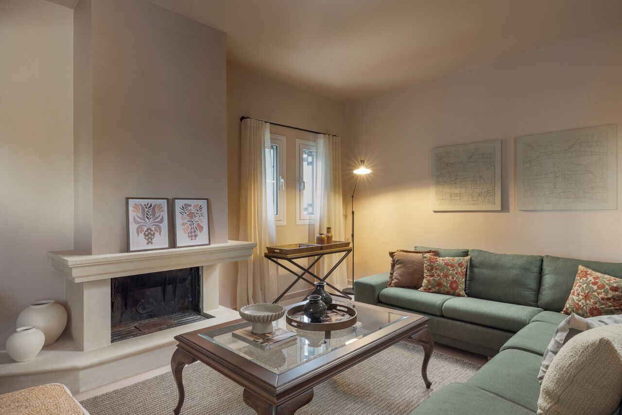A living room with a fireplace, a green sofa, and a coffee table.