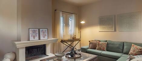 A living room with a fireplace, a green sofa, and a coffee table.