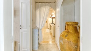 A narrow hallway with a large vase, a door, and a curtain. - Bilocale 104 – Tia Maria Country Inn (Racale)