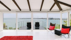 Un balcon spacieux offrant une vue sur la mer et sur le paysage urbain au loin.