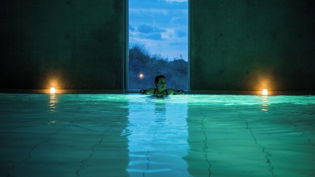 A person in a swimming pool with a view of the sky through a window. - Den Gamle Smedje (Fjerritslev)