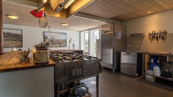 A modern kitchen with a central island, stainless steel appliances, and a variety of utensils and cookware.