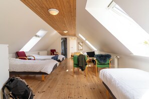 A dormitory room with two beds, a desk, and a chair. There is a skylight and a radiator. - Den Gamle Smedje (Fjerritslev)