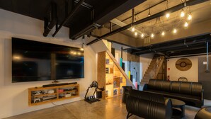 A modern living room with a large TV, gaming console, and exercise equipment. - Host'S EL Fisherman (Koh Samui)