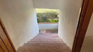Una escalera estrecha que conduce a un balcón con vistas al verdor.