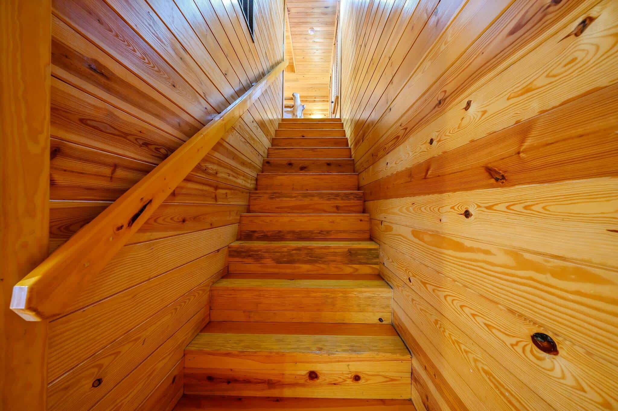 A wooden staircase in a log cabin interior.