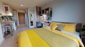 A modern bedroom with a large bed, a desk, and a chair. - Student Only Elgin Place (Glasgow)