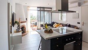 A modern kitchen with a central island, black cabinetry, and a built-in oven. - Charming Holiday Apartment in Nerja (Nerja)