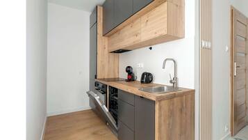 Cafetera o tetera, frigorífico, horno y placa de cocina