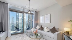 Un soggiorno moderno con un tavolino in vetro, un divano grigio e vista sulla città.