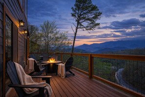 A deck with outdoor seating, a fire pit, and a view of mountains. - Longview Lodge - Mountain Views, Hot Tub, Game Room (Gatlinburg)