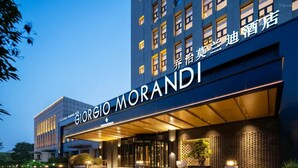 A hotel entrance with a modern facade, large windows, and a prominent sign. - Giorgio Morandi Hotel (Xuzhou City Center) (Xuzhou)