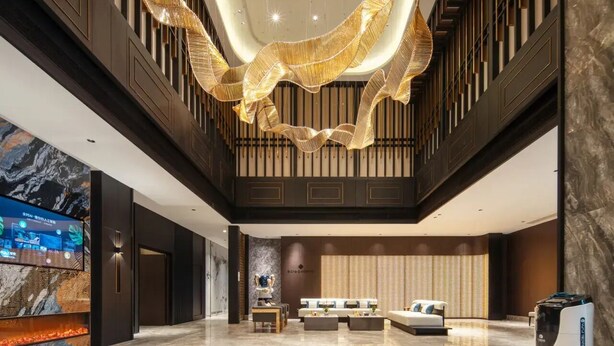 A spacious lobby with a modern chandelier, a reception desk, and a seating area. - Giorgio Morandi Hotel (Xuzhou City Center) (Xuzhou)