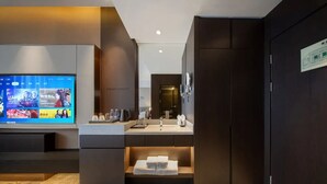 A modern hotel room with a flat-screen TV, a sink, and a mirror. - Giorgio Morandi Hotel (Xuzhou City Center) (Xuzhou)