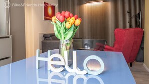Een receptiebalie met een vaas tulpen, een rode stoel en een bordje met de tekst 'Hello Hero'.