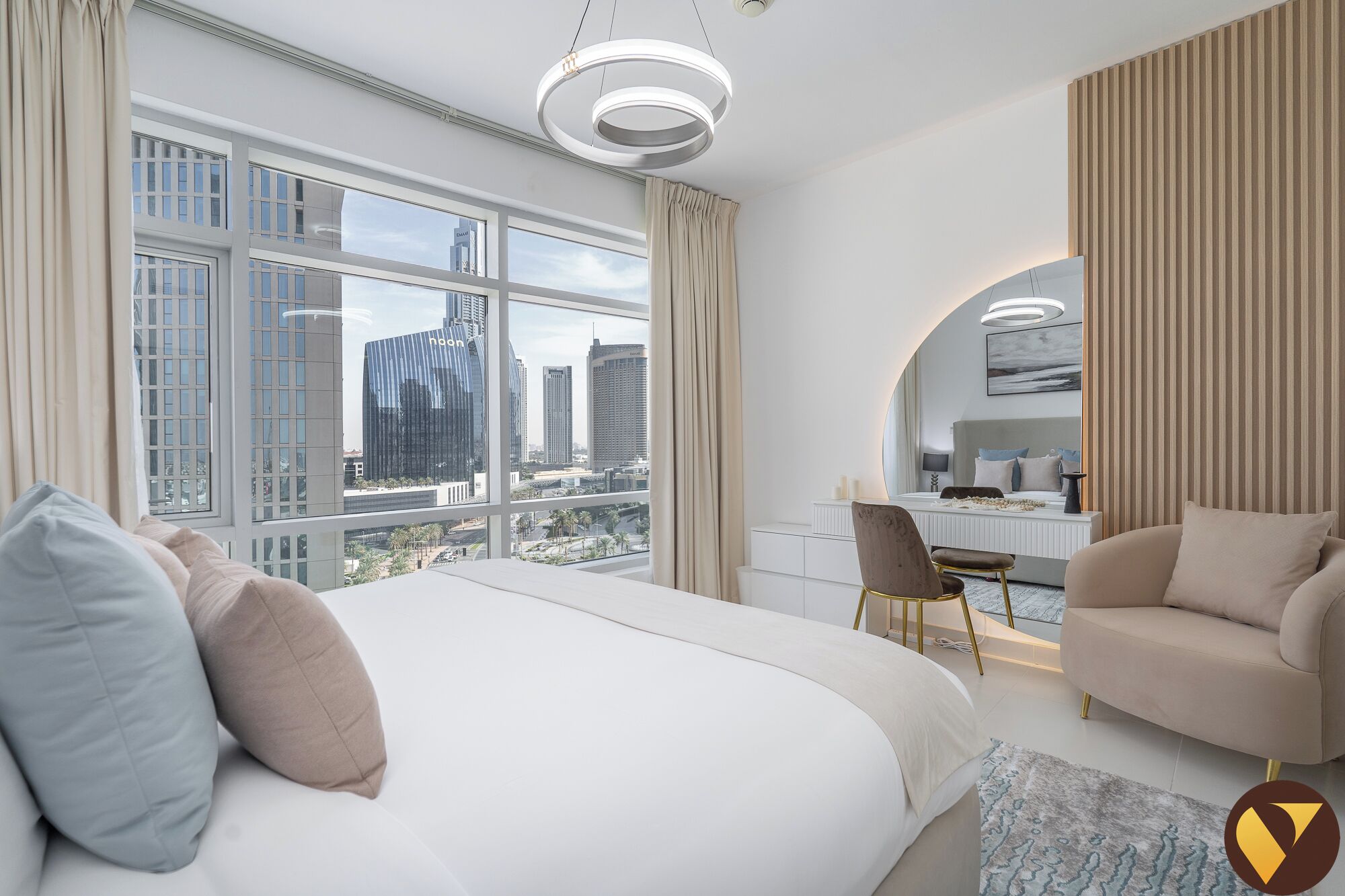 Een moderne hotelkamer met een groot bed, een bureau en uitzicht op de stad.