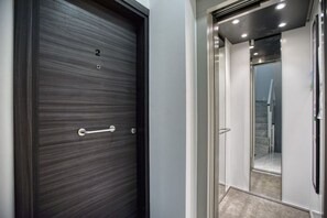 A modern elevator with a metallic interior and a glass door. - Sofia`s Designer Apartment (St. Julian`s)
