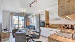 A modern kitchen with a dining area, wooden accents, and a view of the city. - Sofia`s Designer Apartment (St. Julian`s)