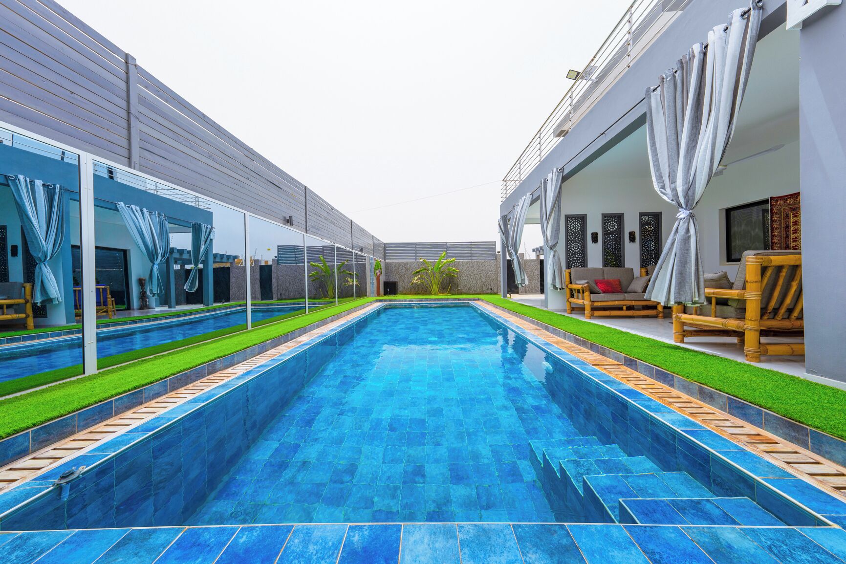 Una piscina al aire libre, sombrillas, sillones reclinables de piscina