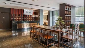 A modern hotel lobby with a reception desk, seating area, and a large window. - Giorgio Morandi Hotel - Xuyi Kejie Central Mall  (Huai'an)