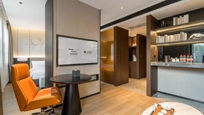 A modern hotel room with a sofa, a small table, a TV, a minibar, and a tea set. - Giorgio Morandi Hotel - Xuyi Kejie Central Mall  (Huai'an)