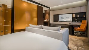 A modern hotel room with a large bed, a desk with a computer, a chair, and a TV screen displaying a presentation. - Giorgio Morandi Hotel - Xuyi Kejie Central Mall  (Huai'an)