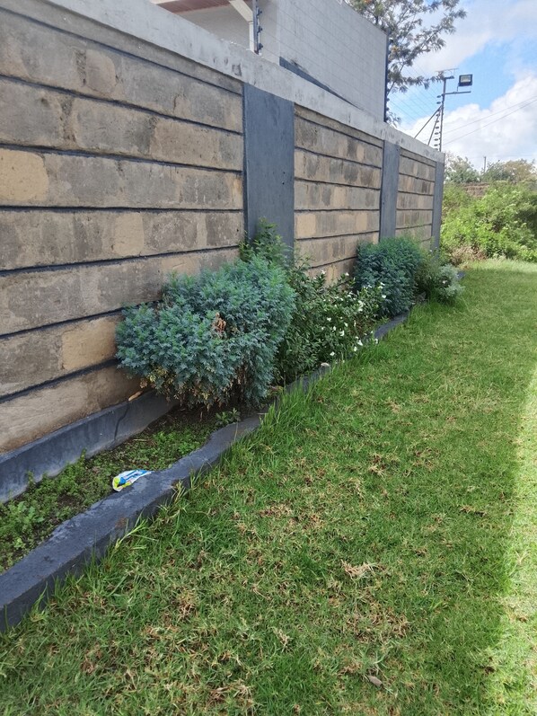 Un muro de piedra con una jardinera que contiene arbustos y plantas pequeñas.