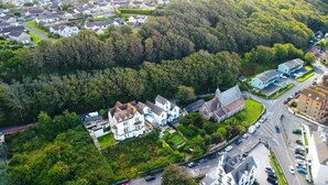 Vue aérienne d’un quartier résidentiel avec des maisons, une église et une route.