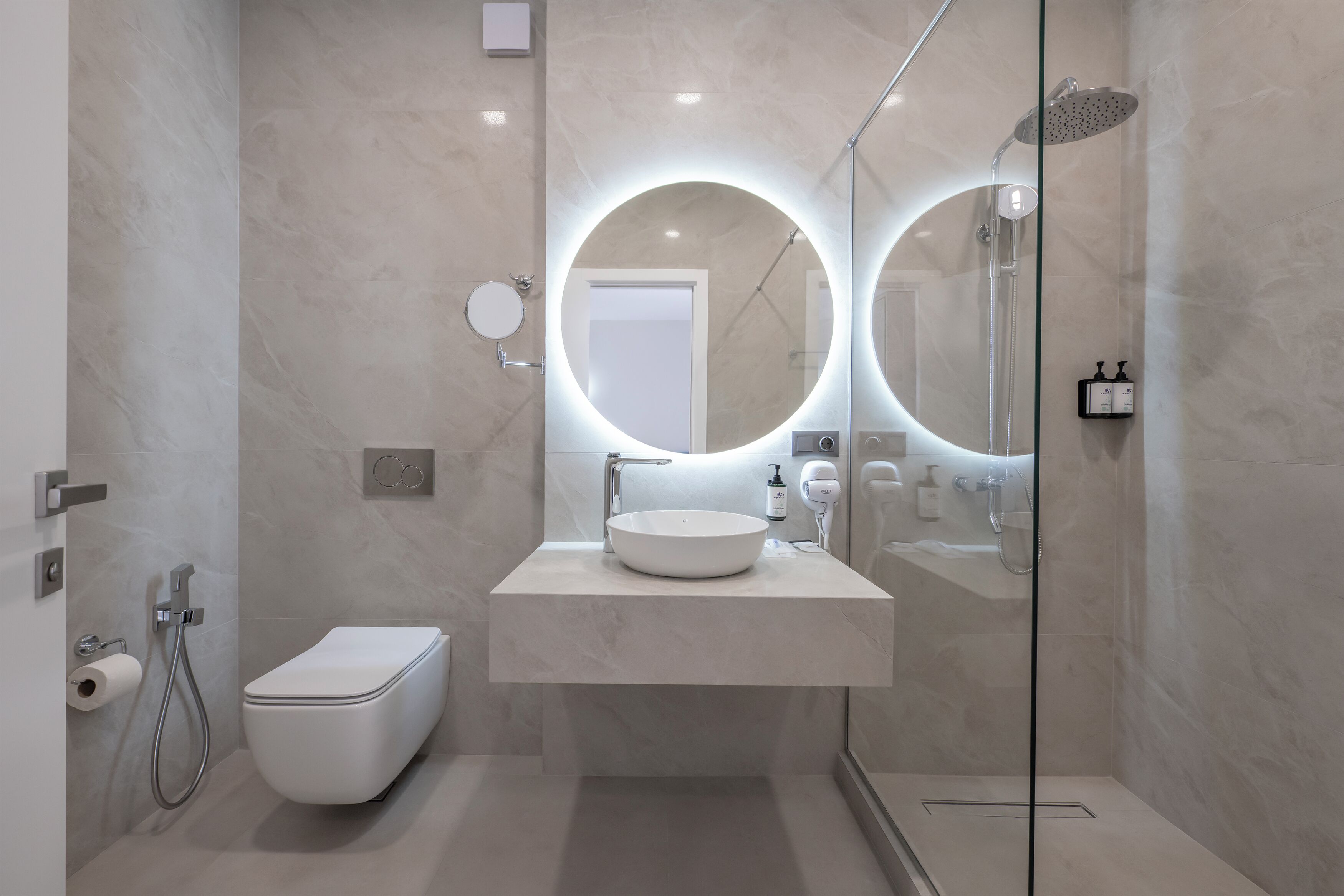 Un bagno moderno con un water, un lavandino e una doccia.