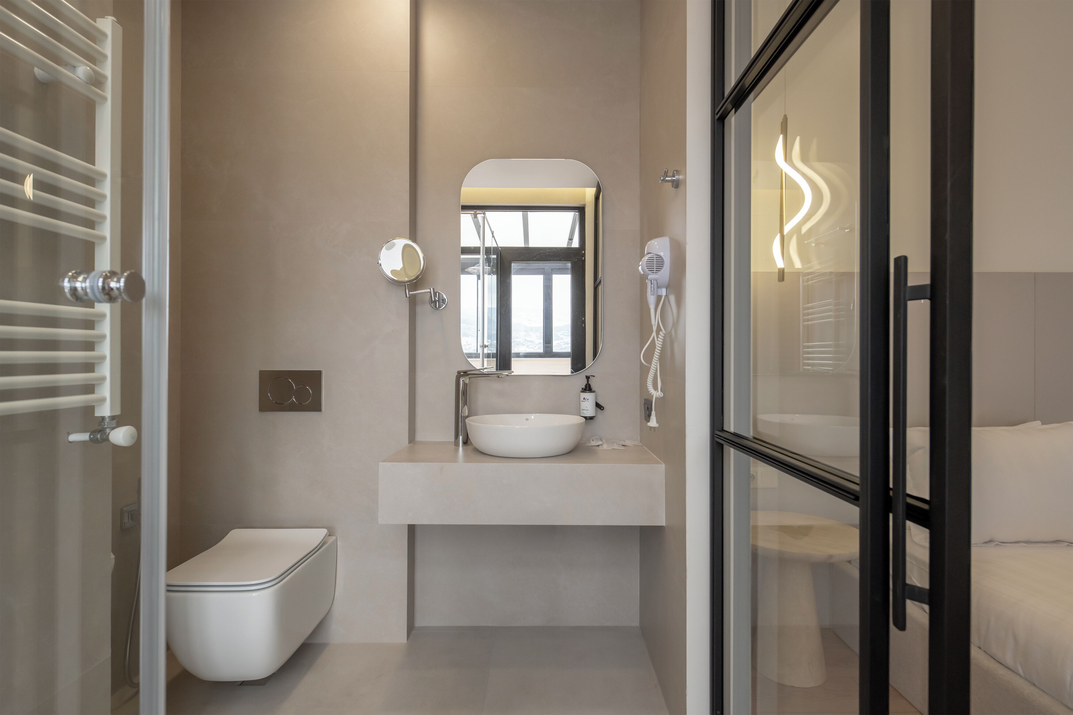 A modern bathroom with a glass shower enclosure, a white sink, and a toilet.