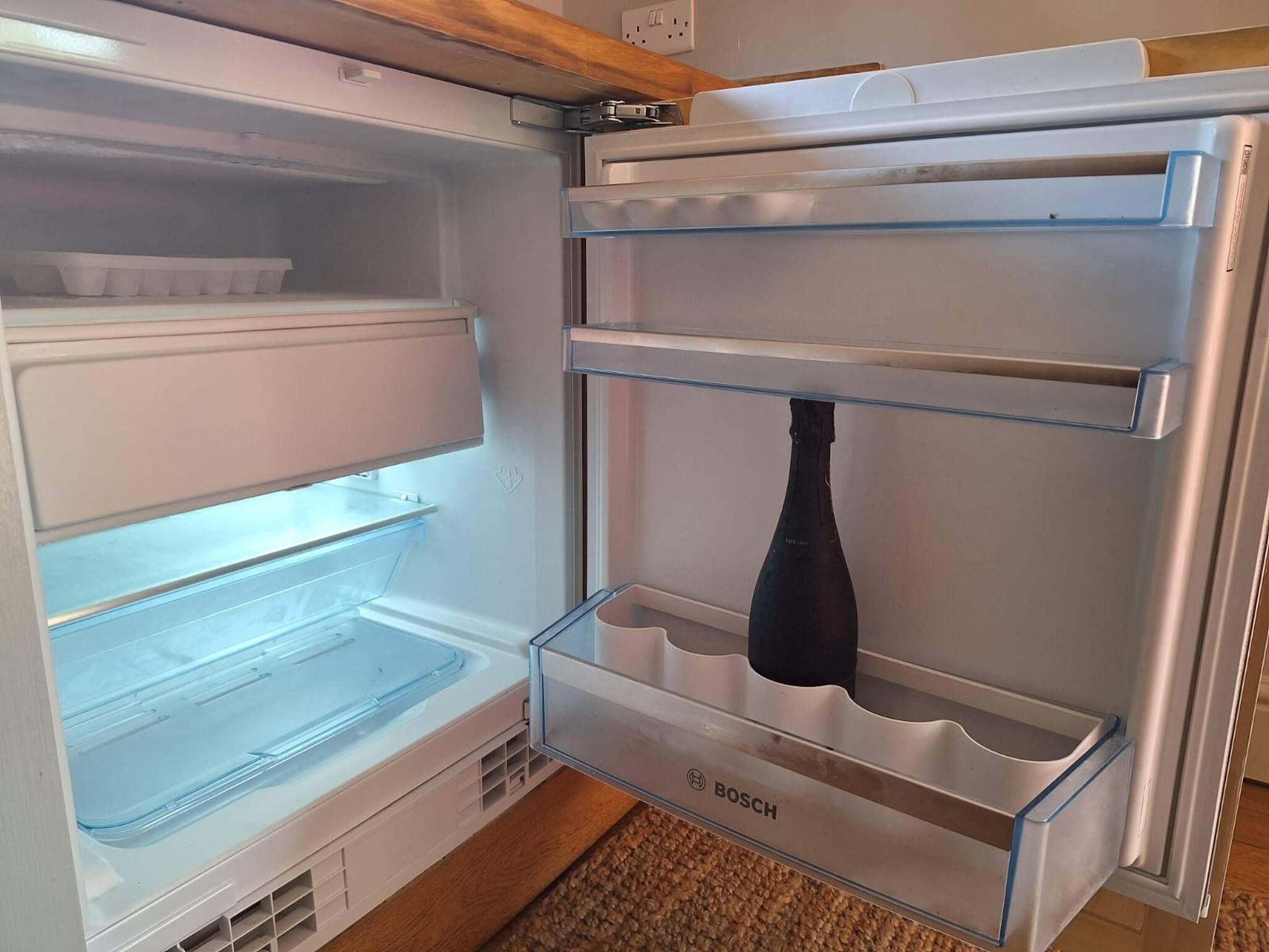 An open refrigerator with multiple shelves and a water dispenser.