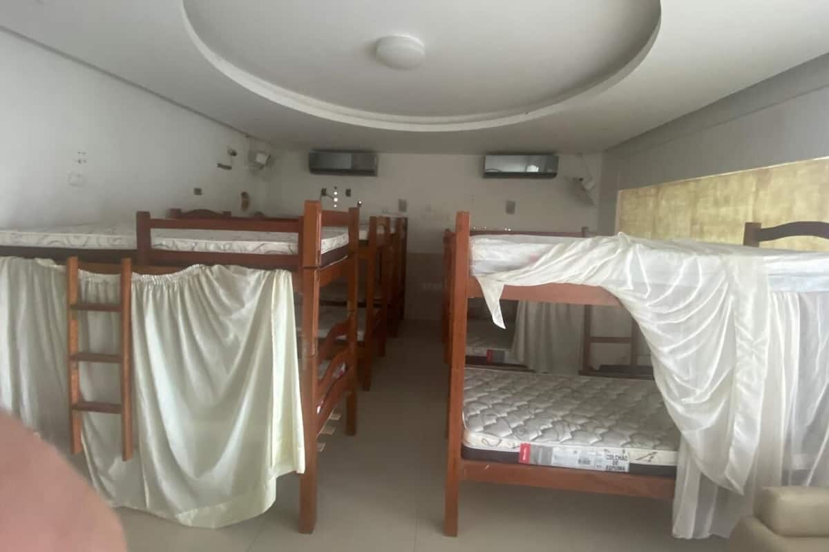 Un dormitorio con camas literas, una lámpara en el techo y una ventana.