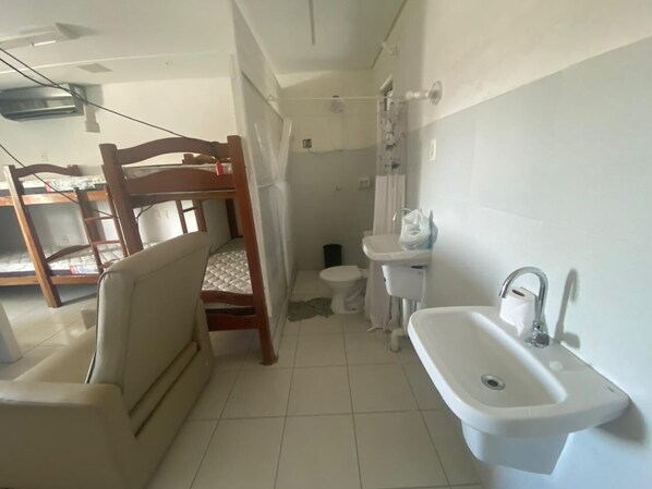 A compact bathroom with a wooden chair, a sink, and a toilet.