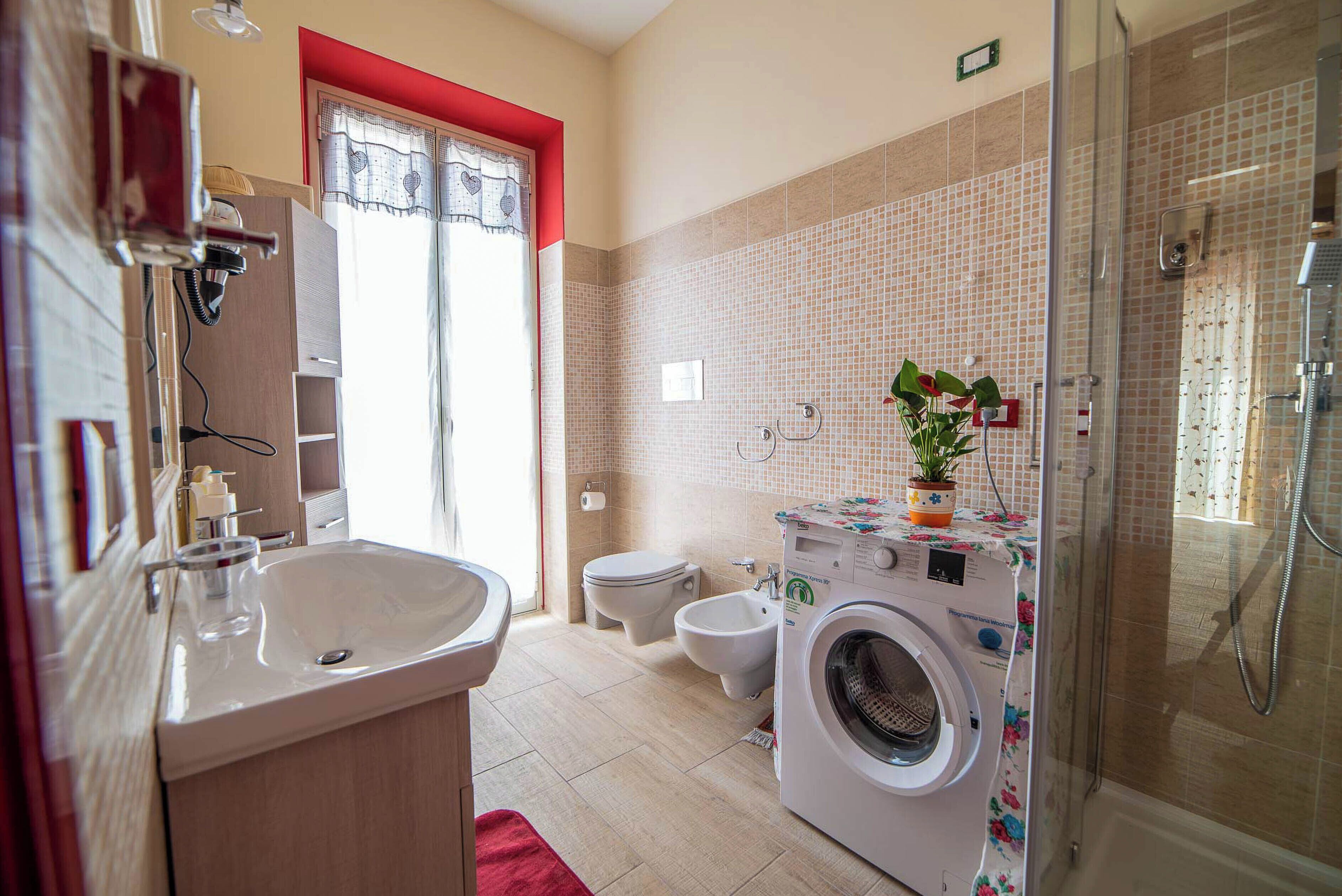 Ein Badezimmer mit Waschbecken, Toilette, Bidet und einer Waschmaschine.