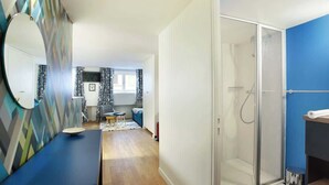 Une salle de bain moderne avec une douche, un lavabo et un miroir.