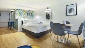Une chambre d’hôtel moderne, équipée d’un lit, d’un bureau et de chaises.