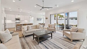 Ein geräumiges Wohnzimmer mit einem großen Couchtisch, zwei Sofas und einem Essbereich mit Tisch und Stühlen.