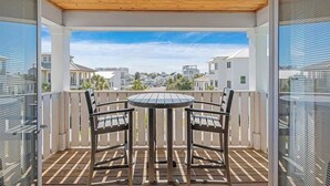 A balcony with a wooden ceiling, two chairs, and a table. - Modern 3-story Beach House W Poll and Billiard (Miramar Beach)