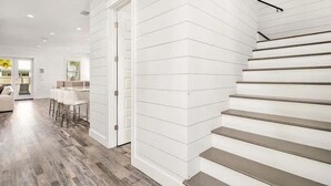 Ein modernes Interieur mit Treppe, Holzböden und einem Essbereich mit weißer Möbel.