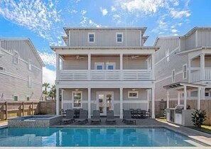 A two-story building with a pool and outdoor seating. - Costal Style 3-story W 7BR and Near the Beach (Miramar Beach)