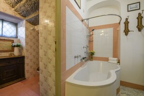 A bathroom with a bathtub, shower, and a vanity with a mirror. - VARESE - Old-time villa next to golf course (Varese)