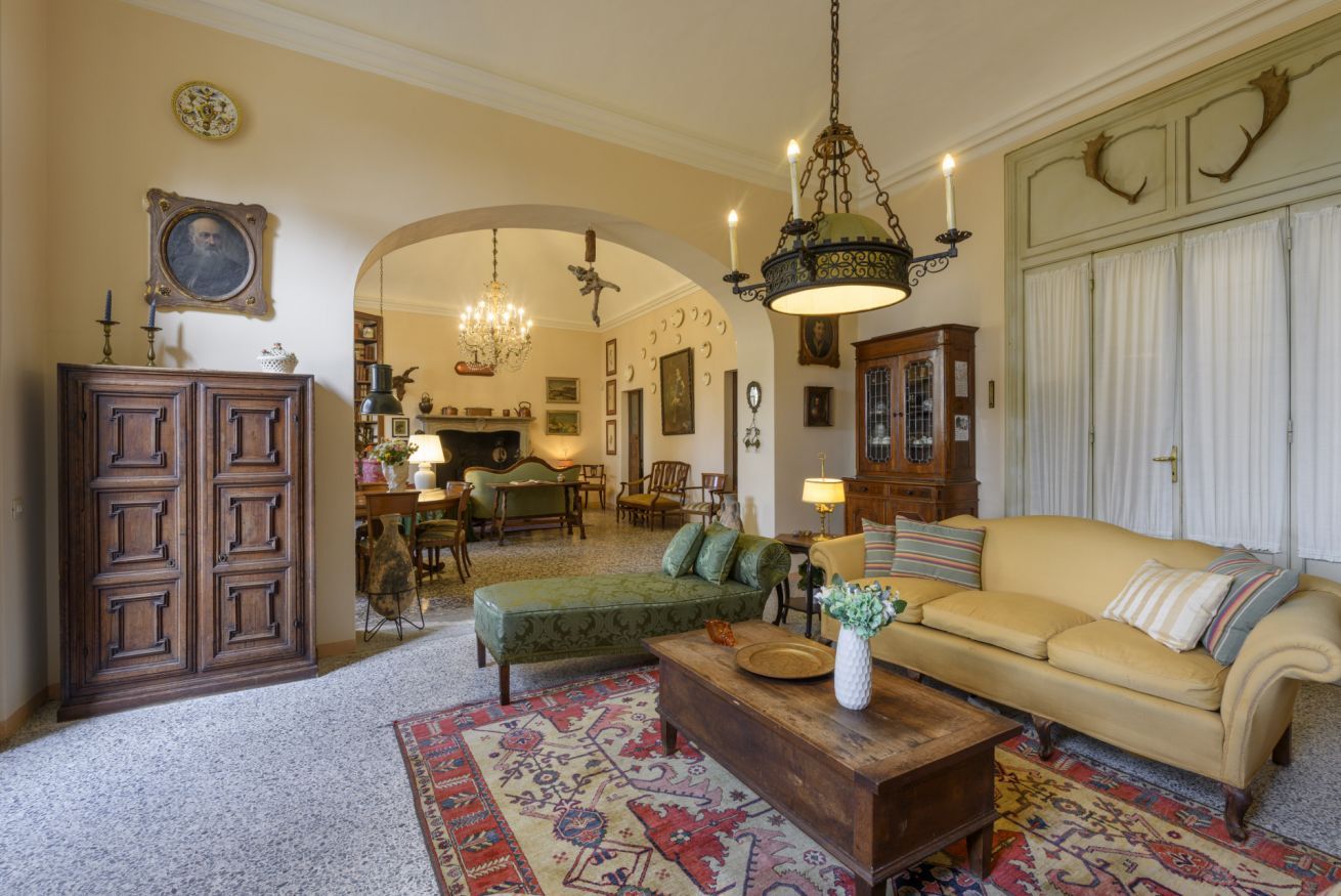 Un salon traditionnel avec un canapé, un meuble en bois, un lustre et un tapis à motifs.