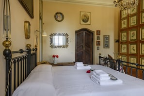 A hotel room with a large bed, a wooden wardrobe, a mirror, and a chandelier. - VARESE - Old-time villa next to golf course (Varese)