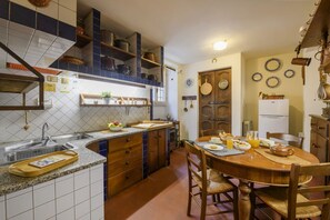 A kitchen with a wooden table, chairs, a sink, cabinets, and a stove. - VARESE - Old-time villa next to golf course (Varese)
