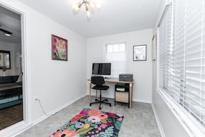 A small, well-lit room with a desk, chair, and a colorful rug. - Stylish Cottage Near Stadium, BeltLine & Downtown (Atlanta)