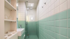 Un baño con lavamanos, ducha e inodoro.
