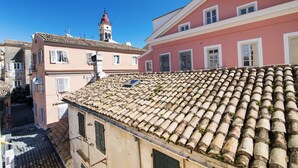 Vista de un edificio con techo de tejas y fachada rosa.