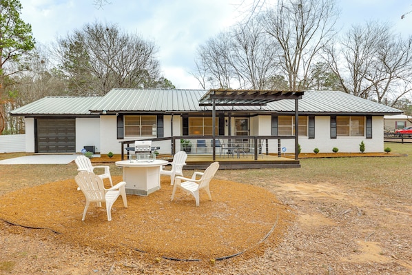 A house with a covered patio, outdoor seating, and a well-maintained lawn. - Hike, Fish & Swim: Nat'l Forest Home in Crockett (Kennard)